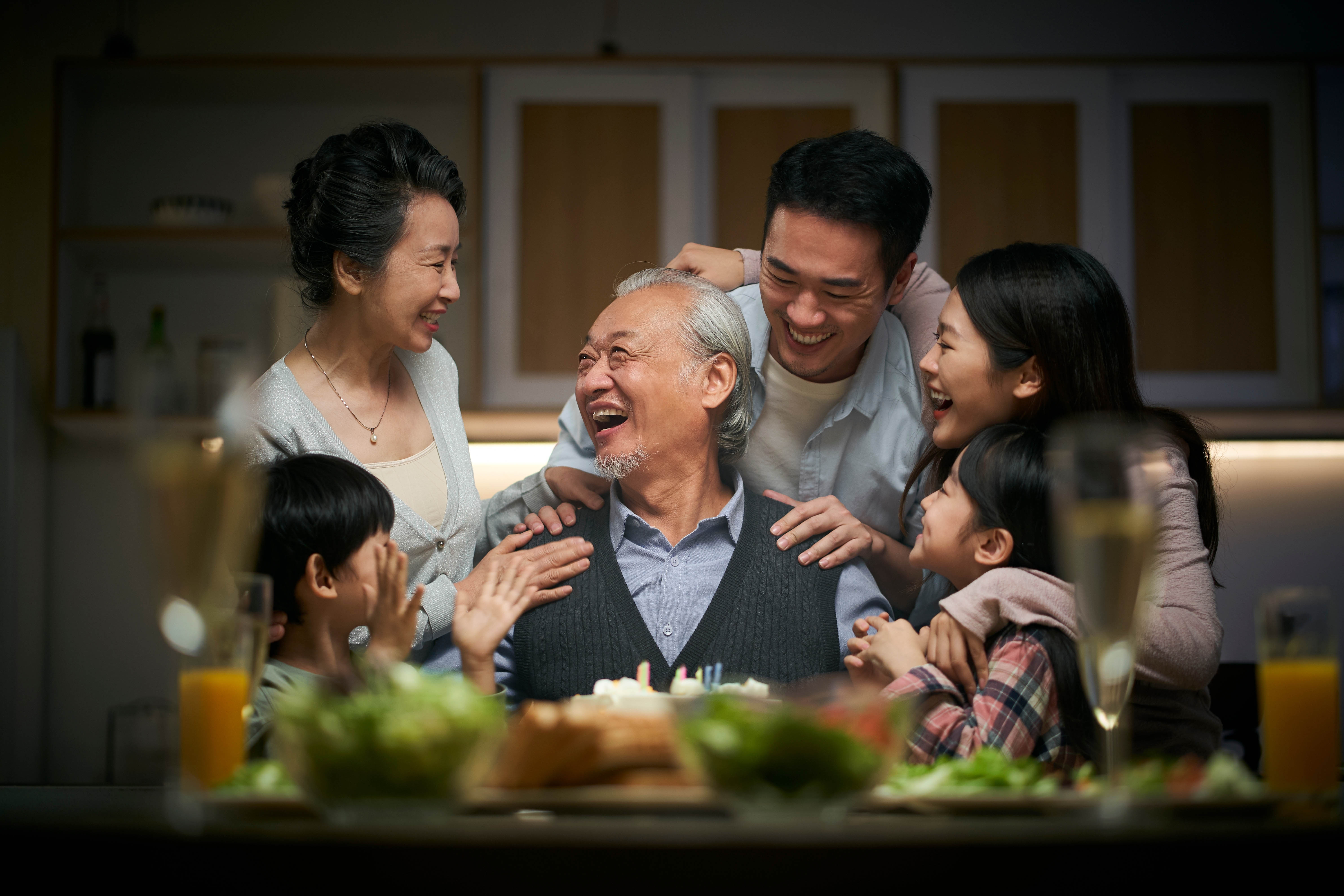 Asian family, centered around the grandfather with his daughter, her children, and two young children around Asian family, centered around the grandfather with his daughter, her children, and two young children around